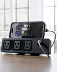 SitonIt Current Power strip with multiple outlets and a smartphone on a wooden surface. Kansas City Office Design.