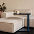 Beige sofa with a Humanscale float micro in Slate Blue holding a mug and a laptop, against a neutral wall. Kansas City Office Design.