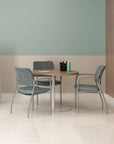 Round table with four chairs in a room with a television on the wall. Kansas City Office Design.