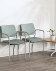 Two green SitOnIt Cora guest chairs with metal frames in a waiting room setting. Kansas City Office Design.