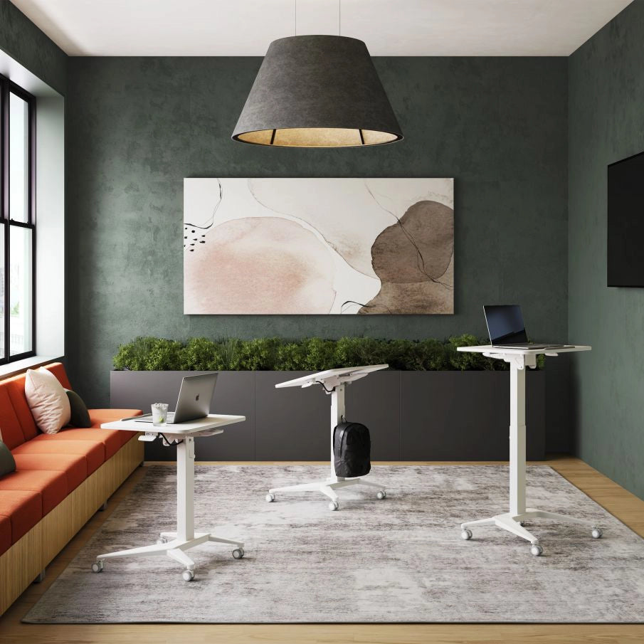 Modern office space with AIS mobile adjustable standing desks and a painting on the wall. Kansas City Office Design