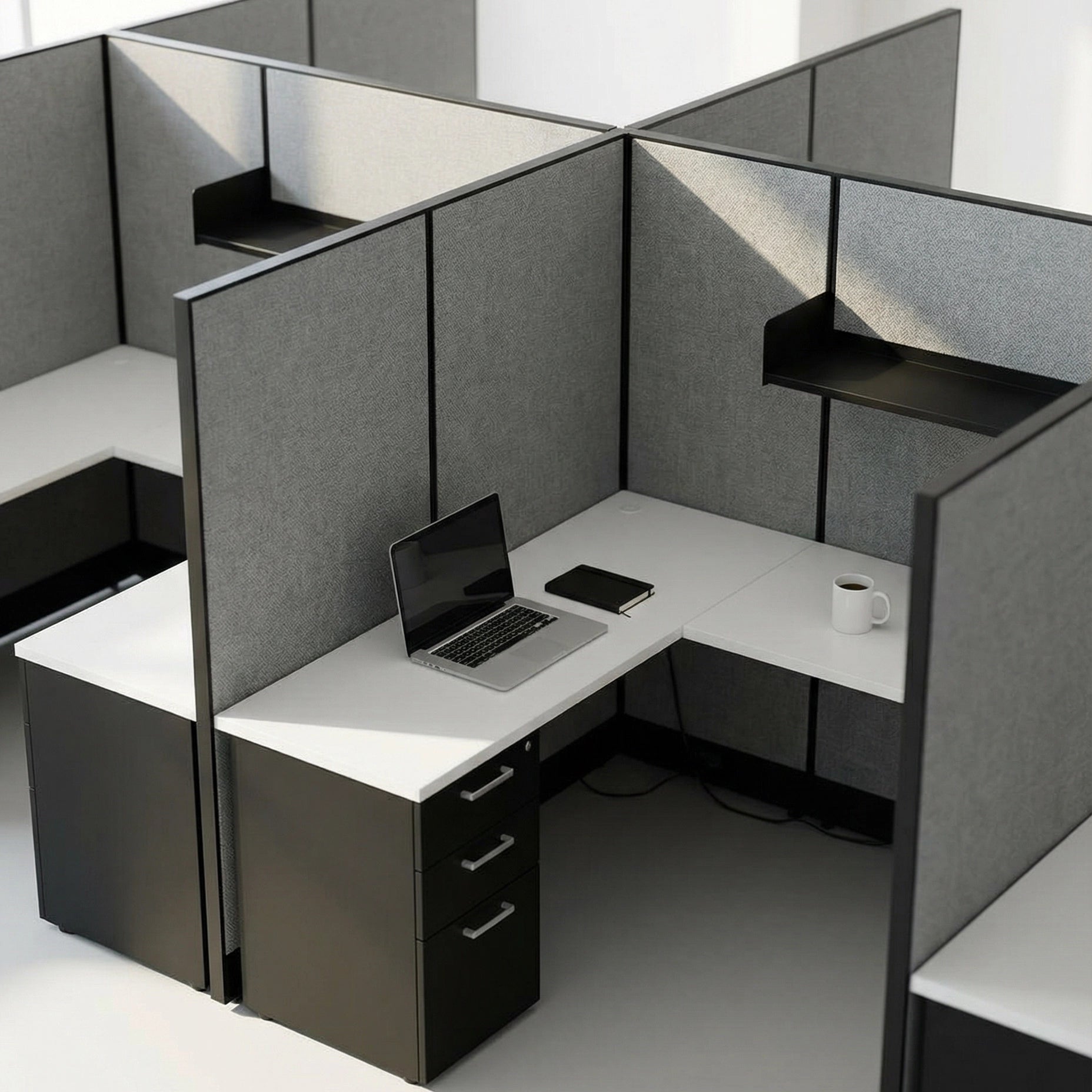 Modern office cubicle with a laptop, phone, and mug on a white desk. Kansas City Office Design