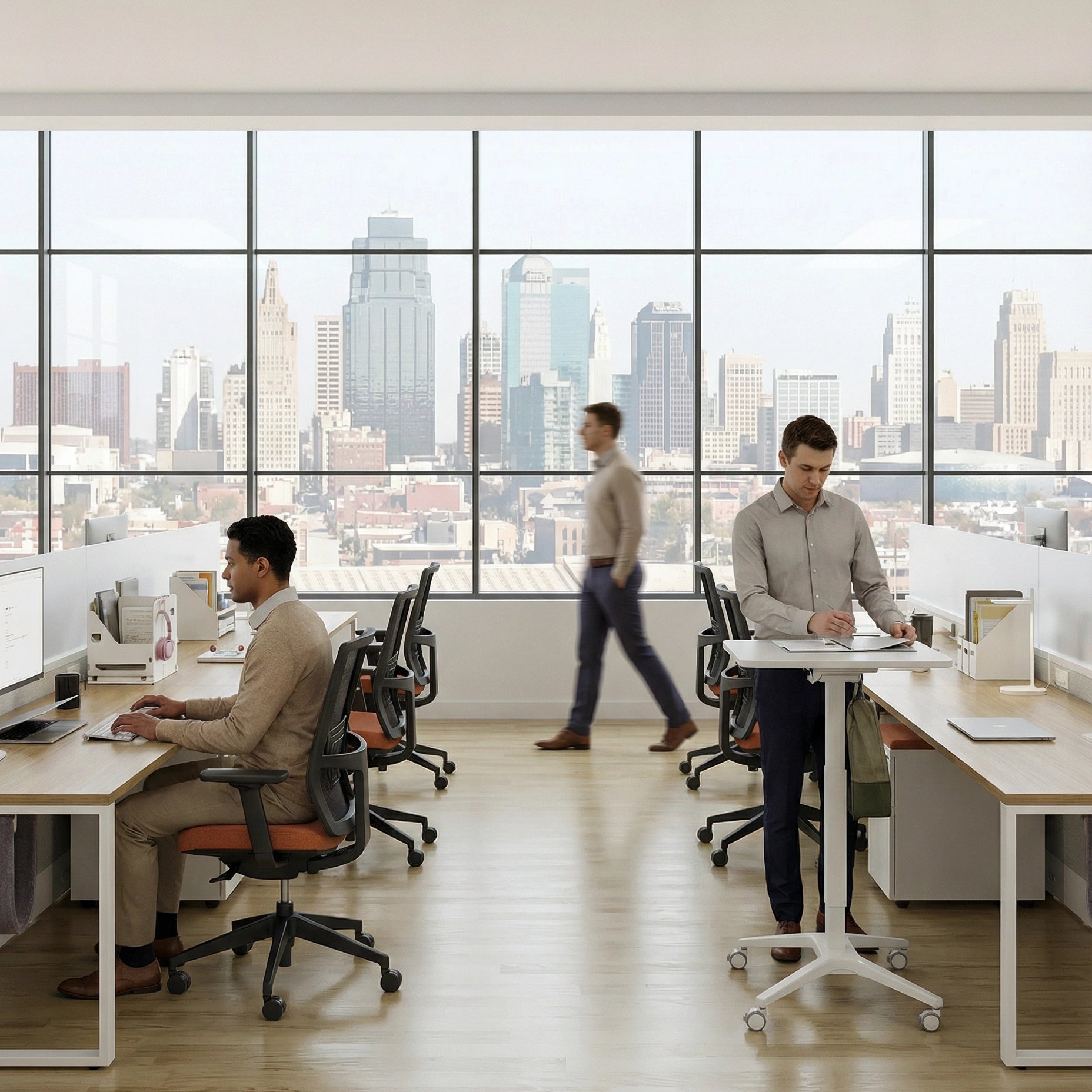 Modern office with large windows overlooking a cityscape, featuring employees at work. Kansas City Office Design