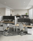 Modern office space with workstations and employees in a bright room. Kansas City Office Design