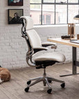 Ergonomic Humanscale Freedom office chair in a modern office setting with a desk and window. Kansas City Office Design.