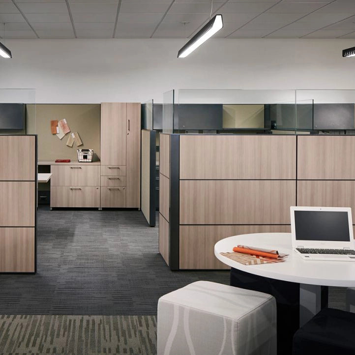 Modern office space with wooden cubicles and a desk with a laptop. Kansas City Office Design
