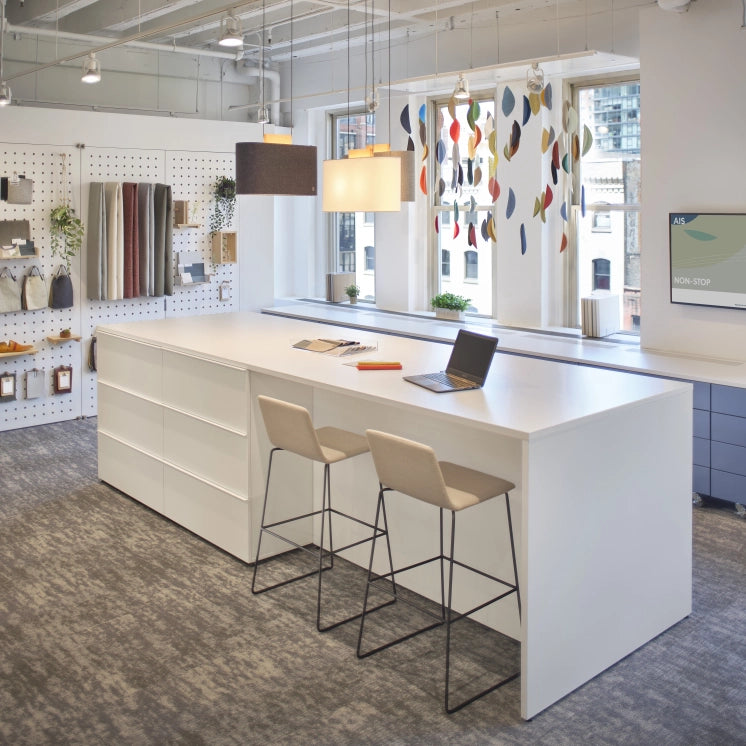 Modern office space with a white desk, stools, and a colorful window blind. Kansas City Office Design.