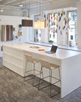 Modern office space with a white desk, stools, and a colorful window blind. Kansas City Office Design.