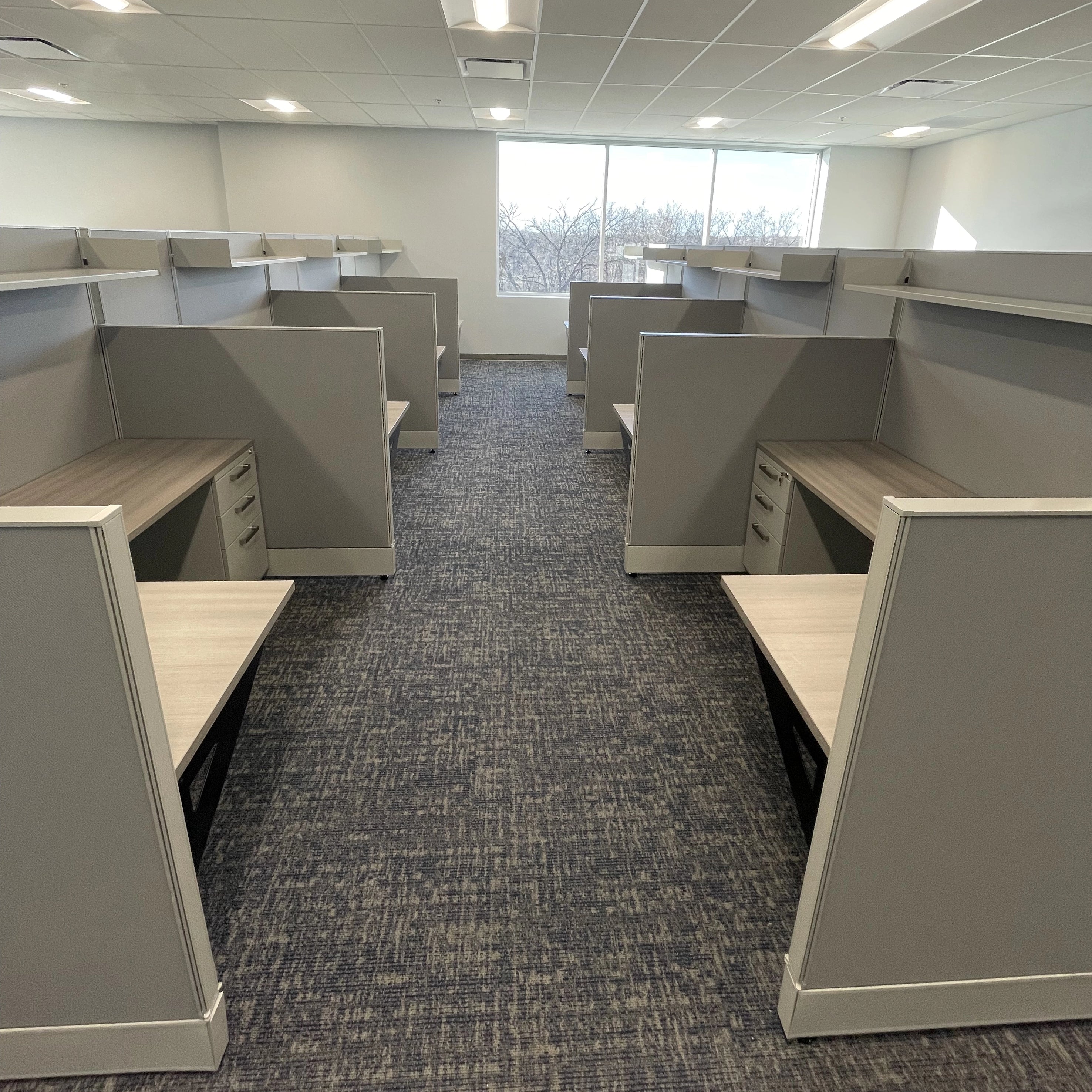 Empty office cubicles with gray walls and carpeted floor. Orange Ev. Kansas City Office Design.