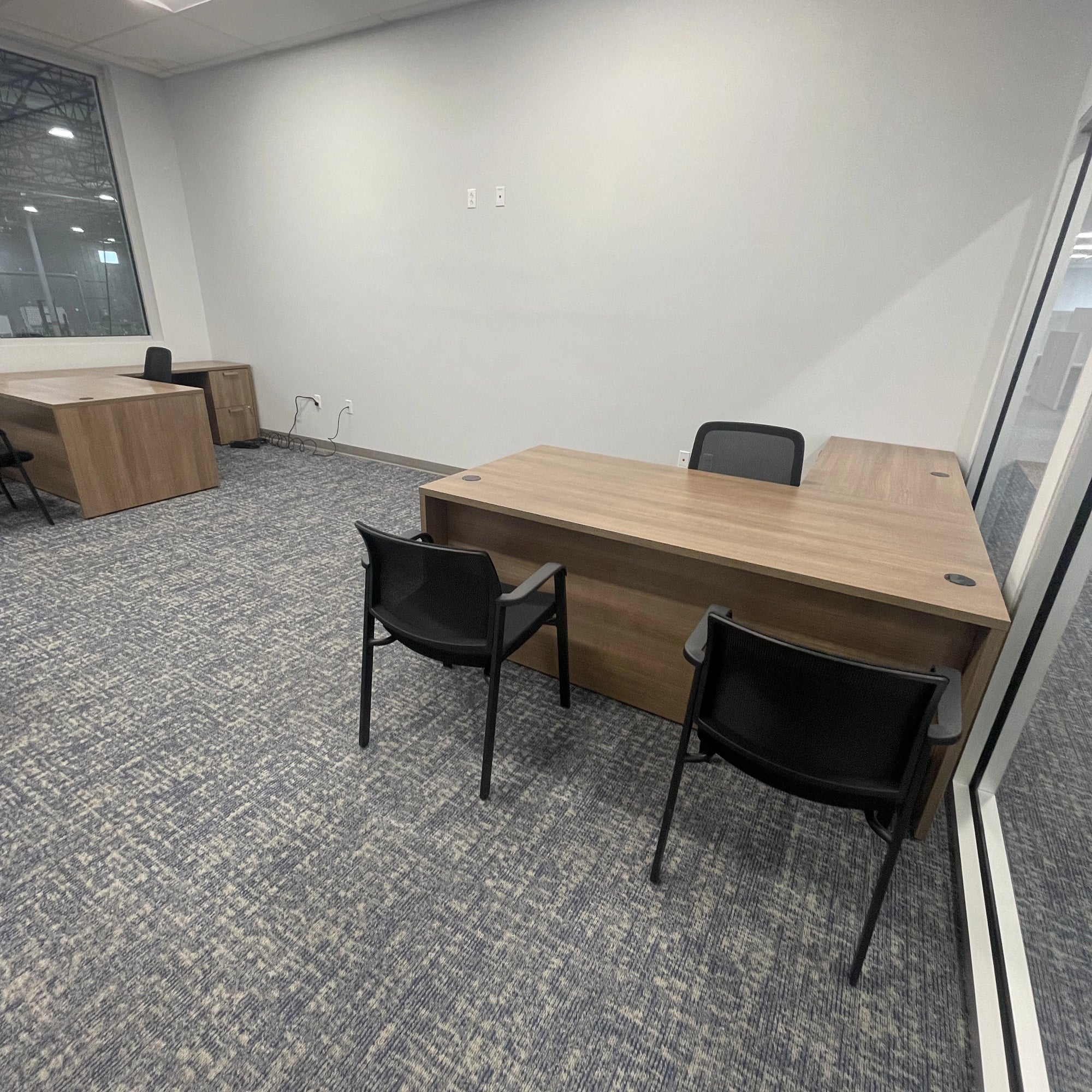 Office space with wooden desks and black chairs. Orange Ev. Kansas City Office Design.