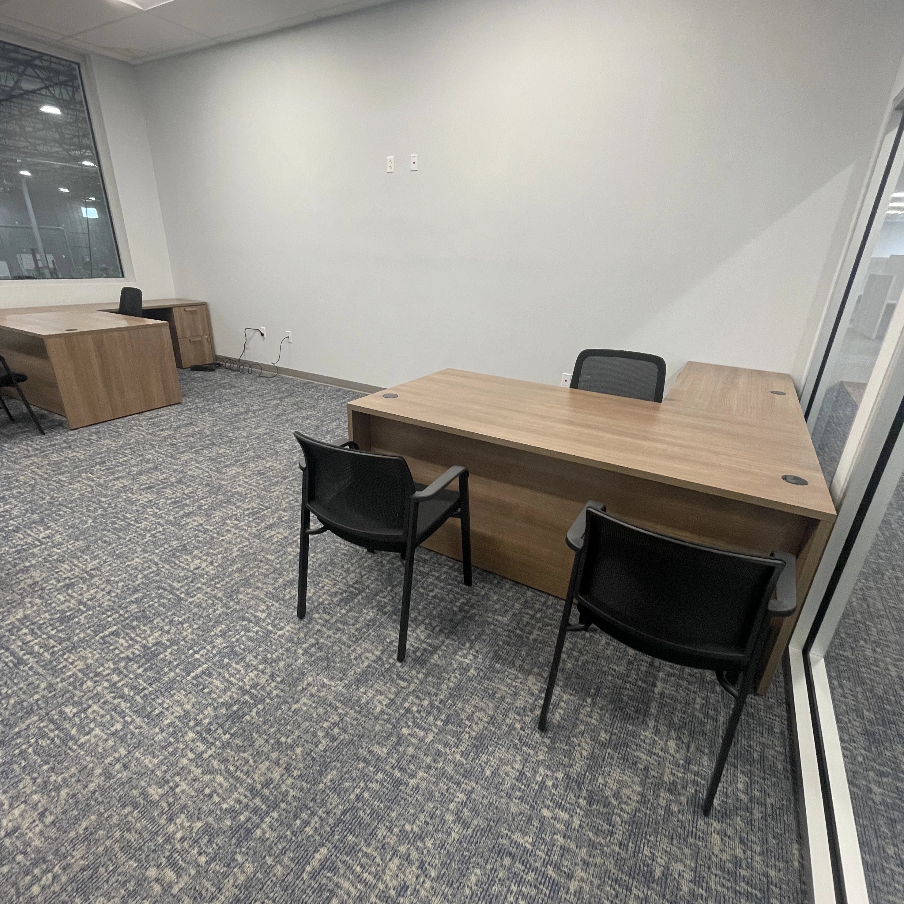 Office space with wooden desks and black chairs. Orange Ev. Kansas City Office Design.