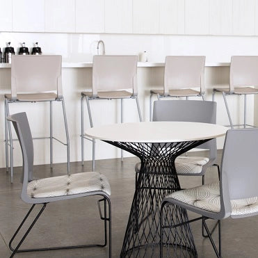 Modern dining area with a round table and chairs in a minimalistic setting. Kansas City Office Design.