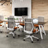 Modern office setup with SitOnIt Hexy chairs, tables, and a TV in a room with wooden walls. Kansas City Office Design