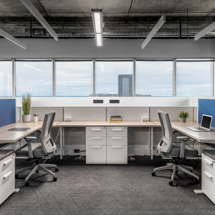 Modern office space with desks, chairs, and large windows. Kansas City Office Design