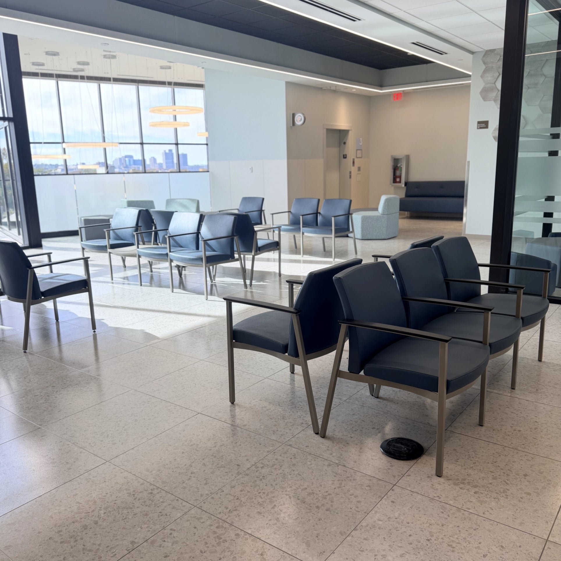 Modern waiting room with blue chairs and large windows. Kansas City Office Design.