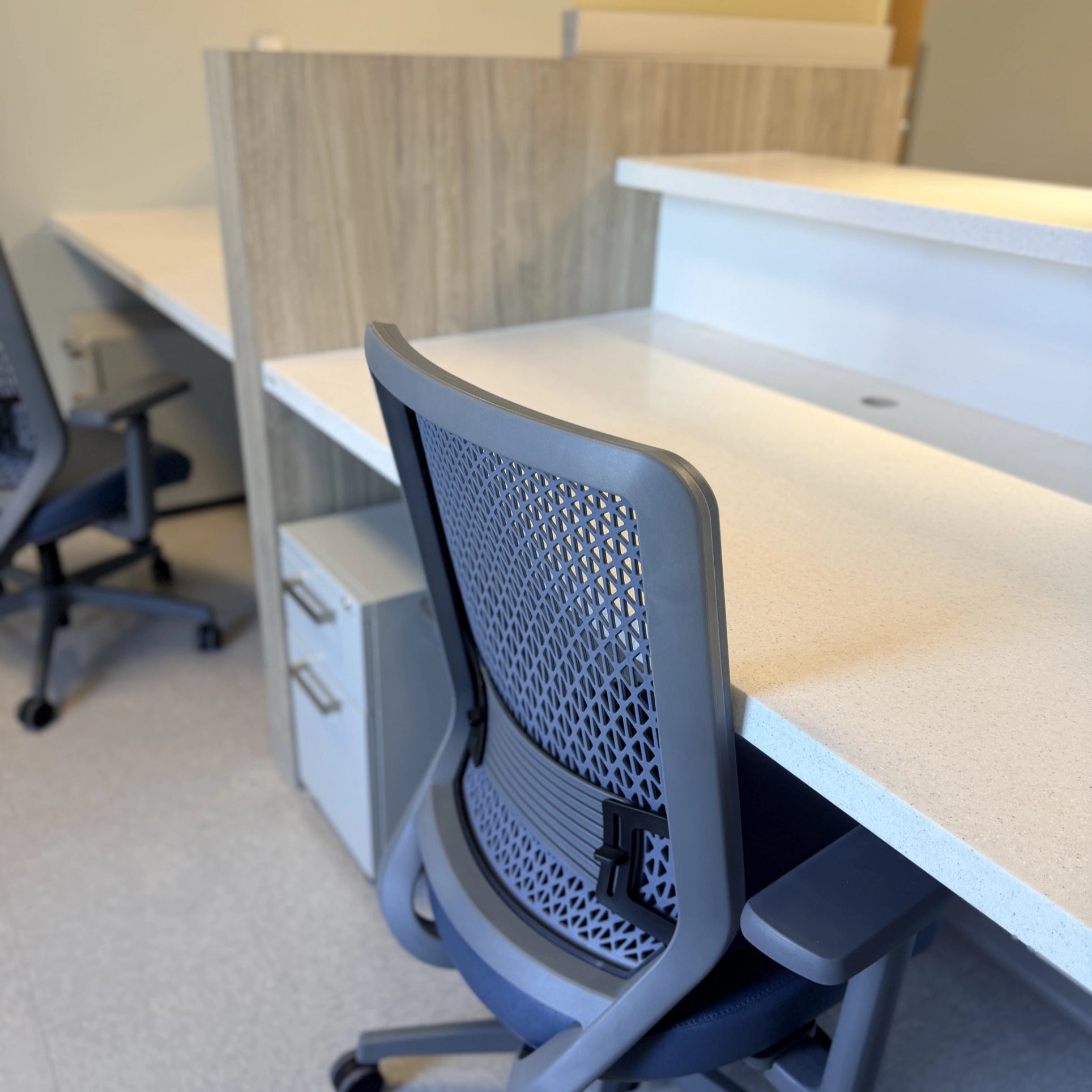 Modern office chair in an office setting with desks and partitions. Kansas City Office Design.