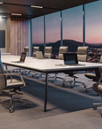 Modern conference room with large table and chairs, overlooking a cityscape at dusk. Kansas City Office Design