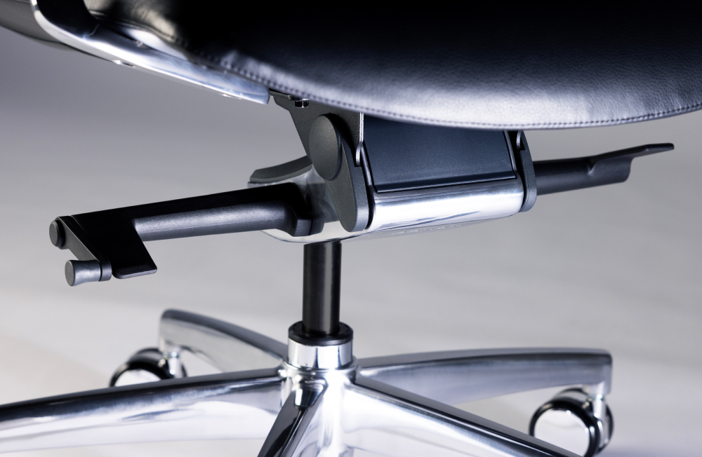 Close-up of a chair's armrest and base on a reflective surface. Kansas City Office Design