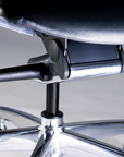 Close-up of a chair's armrest and base on a reflective surface. Kansas City Office Design