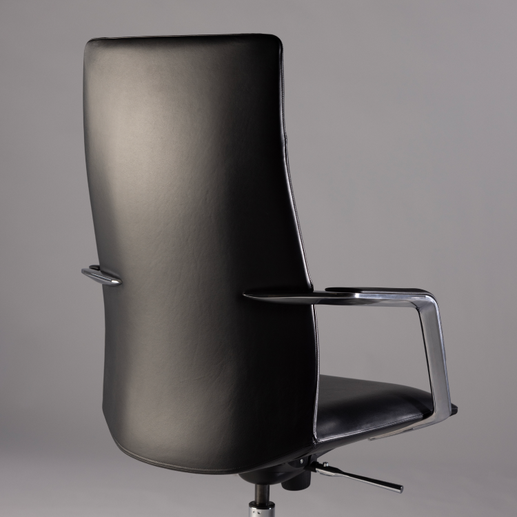 Black office chair with chrome armrests on a gray background. Kansas City Office Design