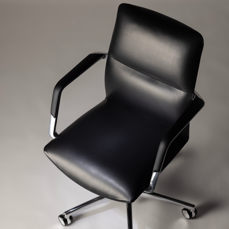 Black office chair with chrome accents on a gray background. Kansas City Office Design