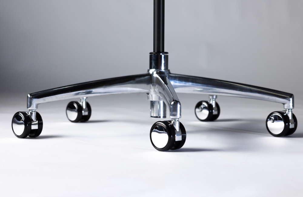 Close-up of a chair's metal base with wheels on a neutral background. Kansas City Office Design