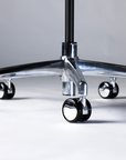 Close-up of a chair's metal base with wheels on a neutral background. Kansas City Office Design