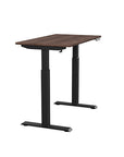 Side view of the SitonIt Switchback Height Adjustable Sit-to-Stand Desk. It has a Black base with a 24"D x 42"W Walnut top - Kansas City Office Furniture