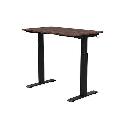 Back view of the SitonIt Switchback Height Adjustable Sit-to-Stand Desk. It has a Black base with a 24"D x 42"W Walnut top - Kansas City Office Furniture