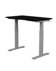 Back view of the SitonIt Switchback Height Adjustable Sit-to-Stand Desk. It has a Silver base with a 24"D x 42"W Black top - Kansas City Office Furniture