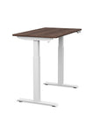 Side view of the SitonIt Switchback Height Adjustable Sit-to-Stand Desk. It has a White base with a 24"D x 42"W Walnut top - Kansas City Office Furniture
