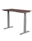 Back view of the SitonIt Switchback Height Adjustable Sit-to-Stand Desk. It has a Silver base with a 24"D x 48"W Walnut top - Kansas City Office Furniture