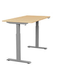 Side view of the SitonIt Switchback Height Adjustable Sit-to-Stand Desk. It has a Silver base with a 27"D x 54"W Maple top - Kansas City Office Furniture