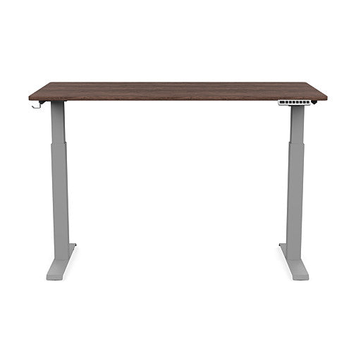 Front view of the SitonIt Switchback Height Adjustable Sit-to-Stand Desk. It has a Silver base with a 27"D x 54"W Walnut top - Kansas City Office Furniture