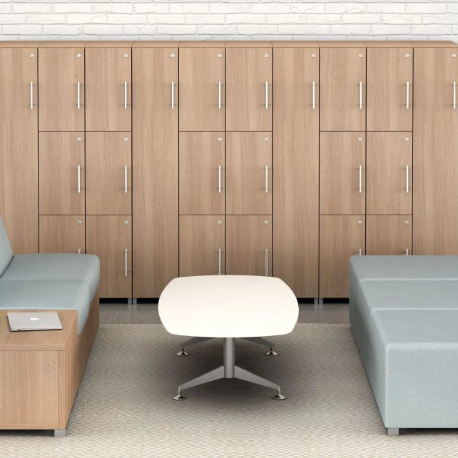 Modern office waiting area with wooden lockers, gray couches, and a white lounge coffee table.