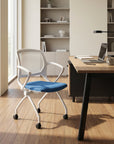 Modern office chair with blue seat in front of a wooden desk with a laptop. Kansas City Office Design.