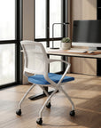 Modern office chair with blue seat in front of a desk with a computer. Kansas City Office Design.