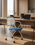 Modern office chair with blue seat in a bright office setting. Kansas City Office Design.