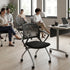 Modern office setting with people sitting on chairs and a desk. Kansas City Office Design.