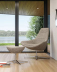 Modern Via Astro Lounge chair and ottoman in a room with large windows overlooking a lake. Kansas City Office Design.