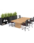 Modern office setup with a long wooden conference table and chairs, black bookshelf, and green plants on a white background. Kansas City Office Design.