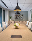Modern conference room with a long wooden table, white chairs, and decorative elements. Kansas City Office Design.