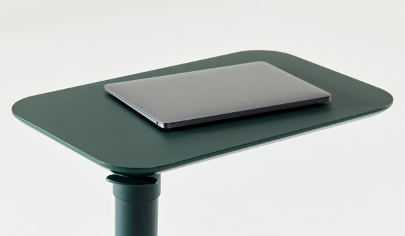 Forest Green adjustable Humanscale Float micro desk with a laptop on a white background. Kansas City Office Design.