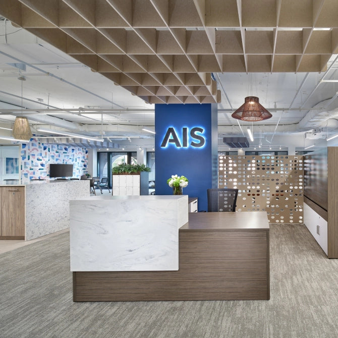 Modern office interior with a calibrate reception desk and 'AIS' sign. Kansas City Office Design.