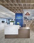 Modern office interior with a calibrate reception desk and 'AIS' sign. Kansas City Office Design.