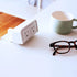 SitOnIt clamp on EON Power with dual outlets on a desk next to a mug and glasses. Kansas City Office Design.