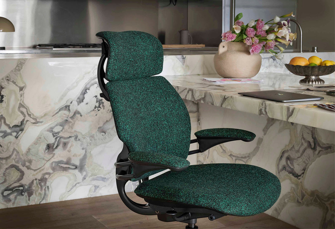 Green Humanscale Freedom office chair in a kitchen setting with a marble countertop and kitchen appliances. Kansas City Office Design.