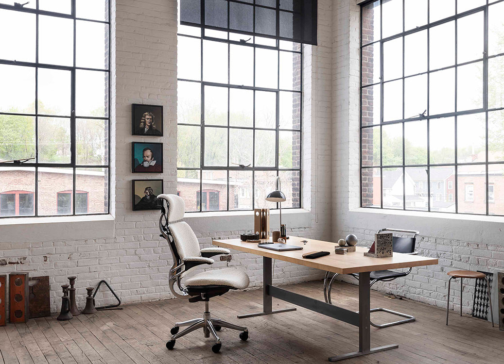 Modern office setup with a desk, Humanscale Freedom chair, and large windows. Kansas City Office Design.