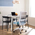 Modern high back Novo office chair with blue seat in a bright room with a desk and laptop. Kansas City Office Design.