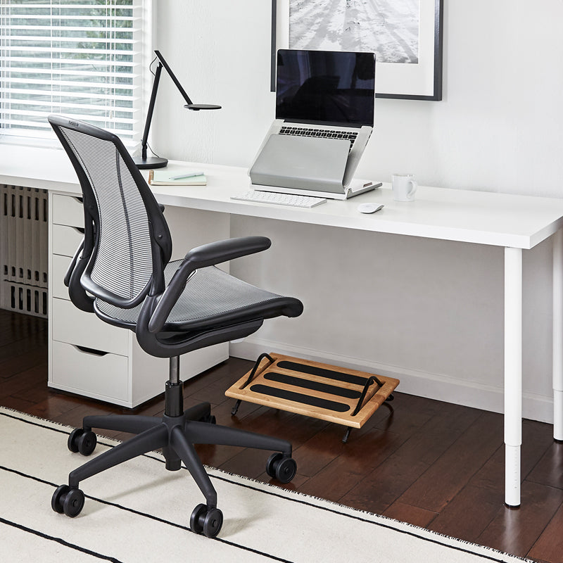 Modern office setup with a black ergonomic chair, white desk, and Humanscale FR300 footrest. Kansas City Office Design. 